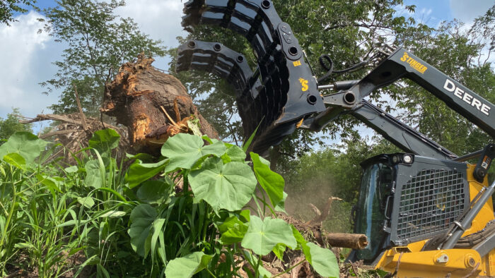 Side view of Stinger Attachments Close Up of Clam Grapple uprooting large tree and roots